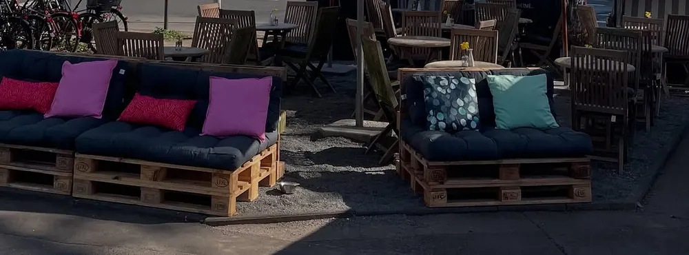 Sitzgelegenheiten aus Paletten mit Kissen auf der Terrasse von Lieblingsice.